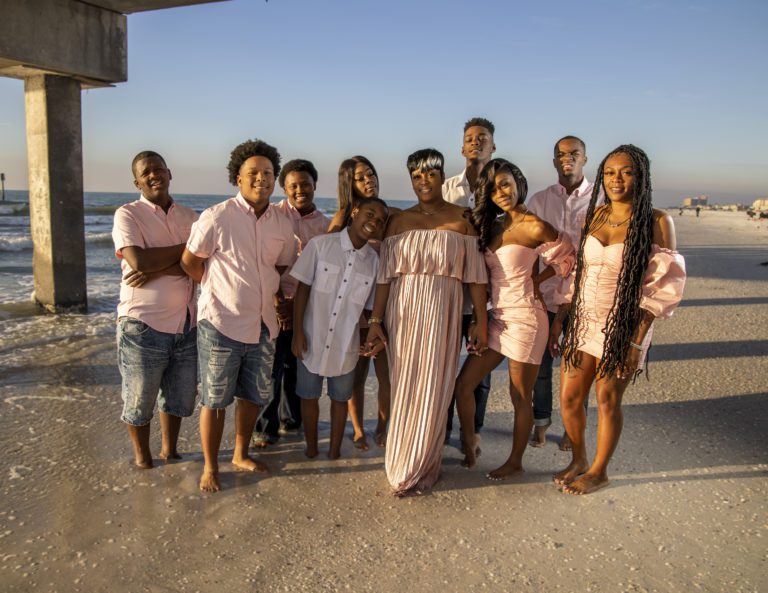 Family standing on shore under boardwalk