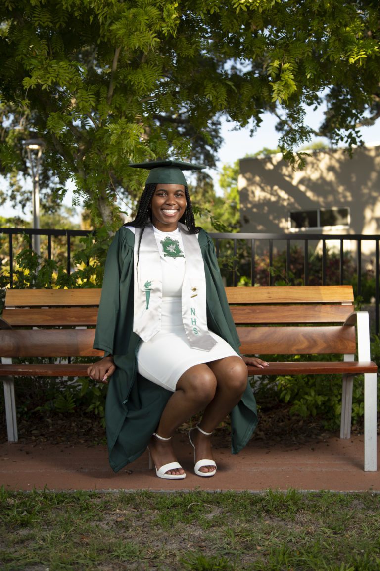 College graduate sitting on a park bench