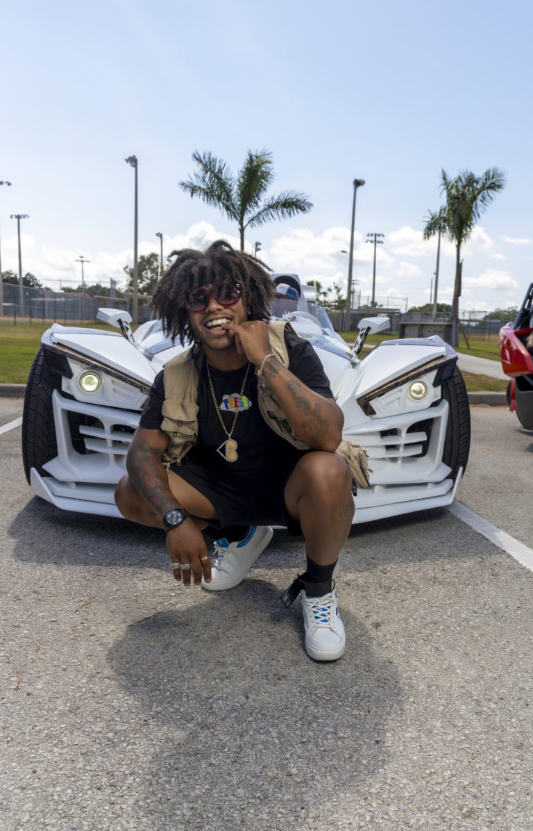 Man squatting in front of car